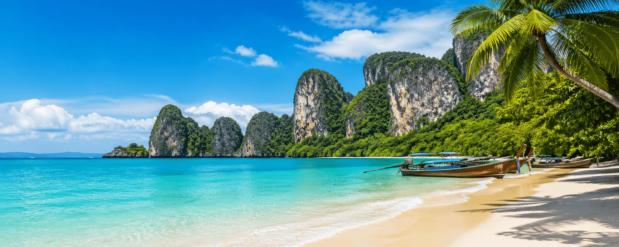 Beautiful tropical beach in Phuket Thailand with turquoise water and longtail boats